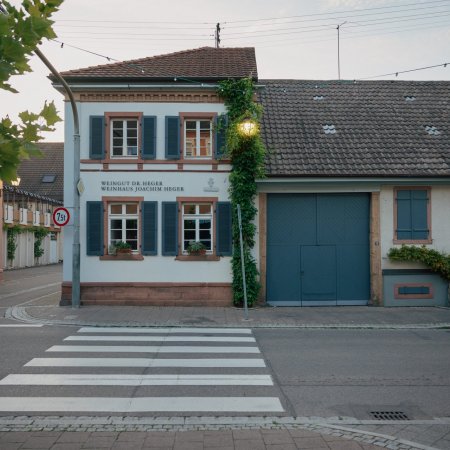 Ein Glas Rotwein neben einer Flasche Wein aus unserem Weingut.